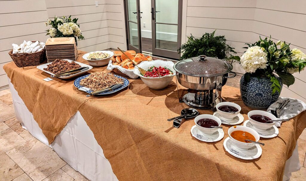 GrillBilly's formal catering buffet with serving dishes, flowers, rolls, and place settings